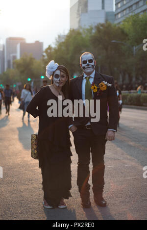 A couple, wearing typical skull makeup and dressed in fashion for the Day of the Dead pose at Mexico's City traditional Day of the Dead parade Stock Photo
