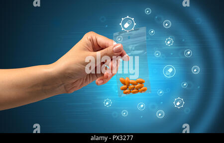 Hand delivers colorful pills in small plastic bag with medicine concept Stock Photo