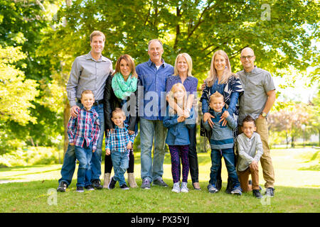 A Family and multi-generation mother, father, children and grandmother having fun on meadow in summer Stock Photo