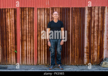 Full body shot of happy bald senior man smiling and standing aga Stock Photo