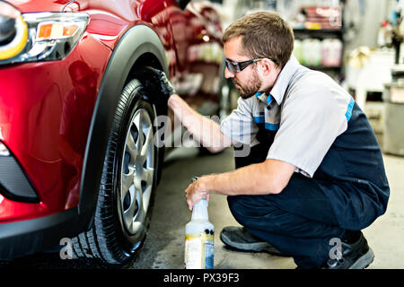 Man at work cleaning automobile at car wash Stock Photo