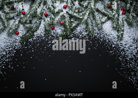 Christmas holiday background with copy space for text. New Year decor with fir branches and holly berries in snow. Flat lay, top view Stock Photo