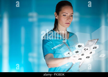 woman doctor or nurse concept that is using innovative technologies to manage her work in the hospital, mixed media with copy space for advertising Stock Photo