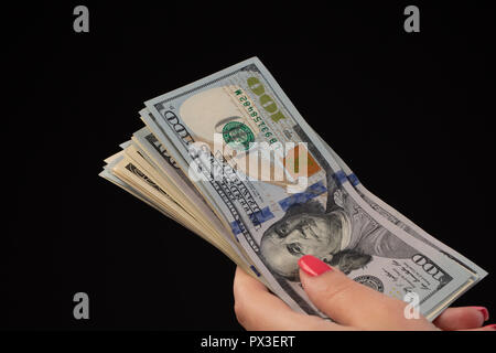 woman hand with hundred dollars bills on a black background. new and old banknotes Stock Photo