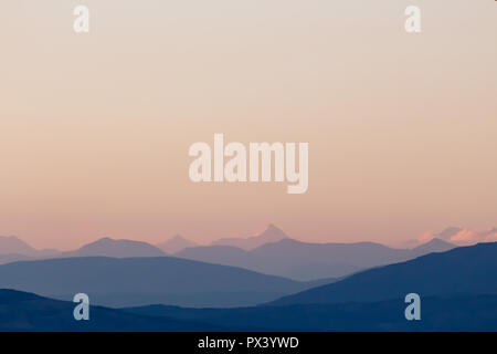 Purple mountain silhouettes and clear sky. Gradient from dark to light purple. Caucasus mountains. Stock Photo