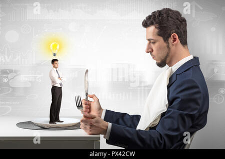 Giant businessman eating small man with financial background  Stock Photo