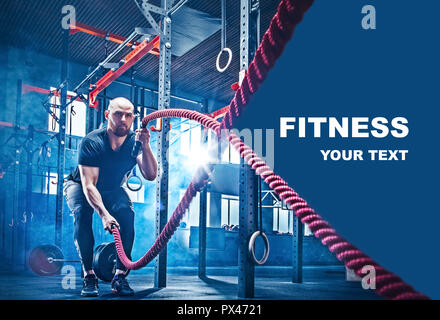 Men with battle rope battle ropes exercise in the fitness gym. CrossFit concept. gym, sport, rope, training, athlete, workout, exercises concept Stock Photo