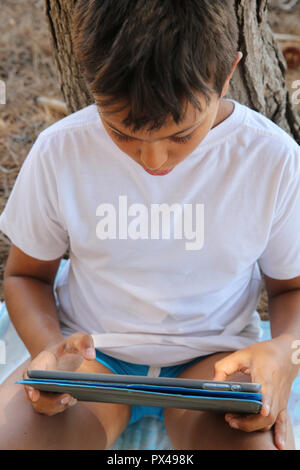 11-year-old boy using a digital tablet in Salento, Italy. Stock Photo