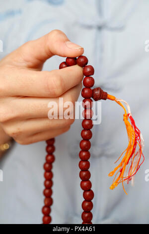 A woman praying Mala beads, the Buddhist prayer beads. Close-up.  Ho Chi Minh City. Vietnam. Stock Photo