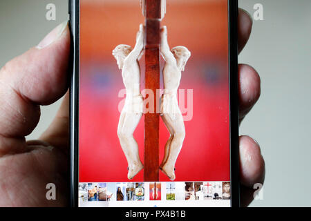 Man looking a picture of Jesus on a smartphone. Stock Photo