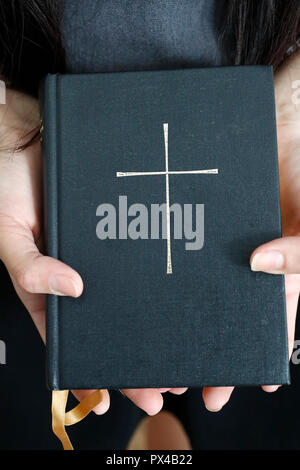 Woman with a bible in hands. Close-up. Stock Photo