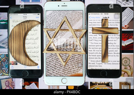 Jewish Star, Christian Cross and and Muslim Crescent, religious symbols of Christianity, Islam, Judaism set on 3 smartphones with digital app. Stock Photo