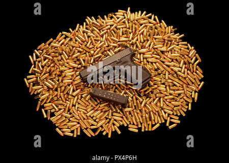 Loaded handgun resting on pile of live ammunition. Stock Photo