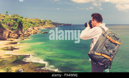 Nature Photography Concept. Professional man photographer with backpack and camera travel outdoor Stock Photo