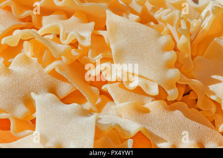 A heap of dry Italian pasta called pantacce   ,rhombus -shaped pasta with wavy edge ,funny composition , studio shot , top view, high contrast , selec Stock Photo