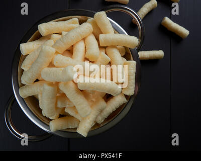 Puffelets Snack Crunchy corn puffs, pufuleti on bowl isolated over white. Romanian ...
