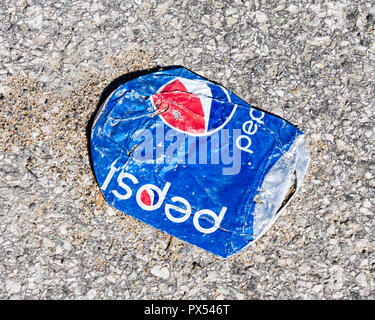 A flattened aluminum Pepsi can on the road run over by vehicles in Speculator, NY USA - waste and litter concept. Stock Photo