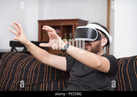 Bearded man wearing virtual reality goggles Stock Photo