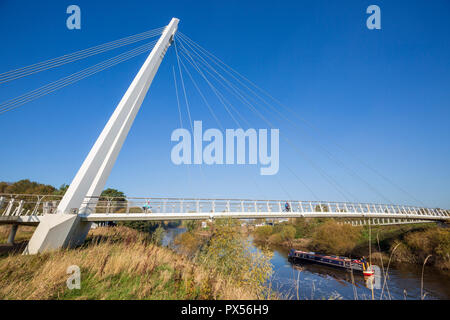 Canal barge traveling along the River Severn passing under Diglis Foot Bridge at Worcester, Worcestershire, England Stock Photo