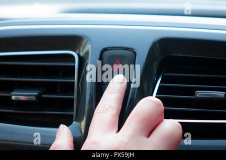 woman pushes a button in the car Stock Photo