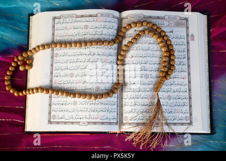 Open Kuran and prayer beads. Stock Photo