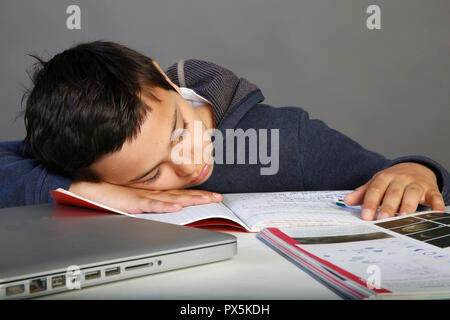 12-year-old schoolboy falling asleep on his homework. Paris, France. Stock Photo
