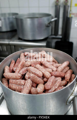 Cooking diots in a kitchen. A diot is a sausage from the French region of Savoy.  France. Stock Photo
