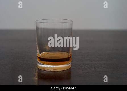 Whiskey, Bourbon, Scotch or Rum in an Elegant Tumbler on a Dark Wooden Table Stock Photo