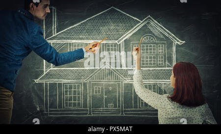 Young couple sharing thoughts together drawing the dream house on blackboard. Home planning, people idea exchange, life partnership and teamwork innov Stock Photo