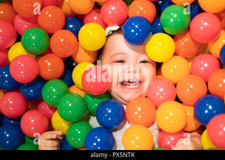 A Portrait of a adorable infant on colorful balls Stock Photo