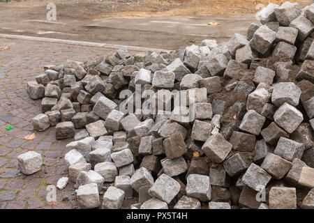 Pile of cobblestones on the ground, ready to be laid Stock Photo