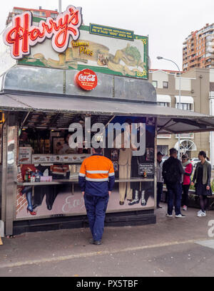 Workmen and tourists buying food from the iconic Harry's Cafe de Wheels   food van on Cowper Wharf Road Sydney NSW Australia. Stock Photo