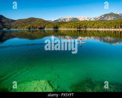 Image of stand up paddling on a beautiful mountain lake in autumn Stock Photo