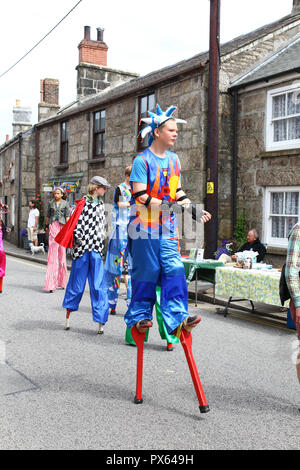Young girl walking on stilts at the Lafrowda festival at St. Just in Penwith, Cornwall, England, UK