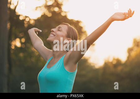 Beautiful woman enjoys with her arms outstretched in the nature. Stock Photo