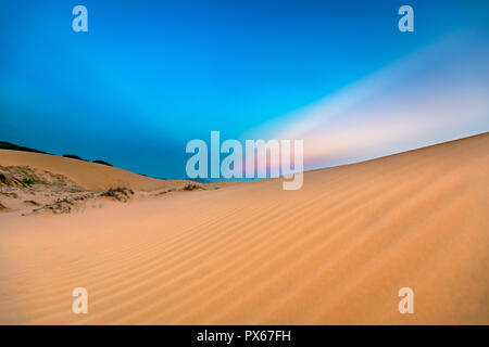 Sunset on the dunes hill with pink rays in the sky so mysterious and interesting to watch them Stock Photo