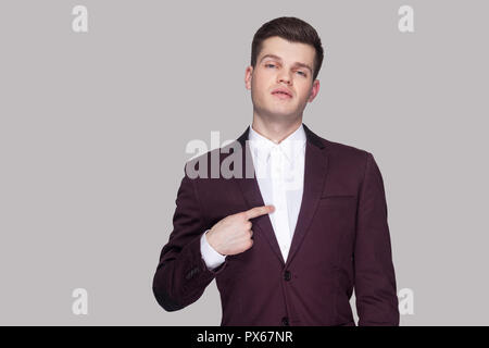 This is me. Portrait of proud handsome young businessman in violet suit and white shirt, standing, looking at camera and pointing himself and bragging Stock Photo