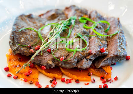 Sliced beef with pumpkin served on white plate Stock Photo