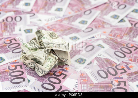 crumpled hundred dollar bill against the background of money in denomination of five hundred euro Stock Photo