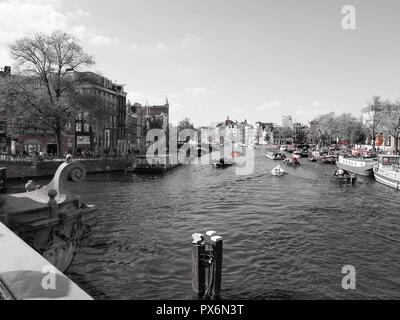 Red on Black and white image of Canal in Amsterdam Stock Photo