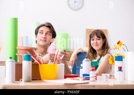 Couple decorating pots in workshop during class Stock Photo