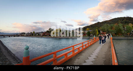 People on the bridge over Uji River in autumn sunset panoramic city scenery. Uji, Kyoto Prefecture, Japan 2017 Stock Photo