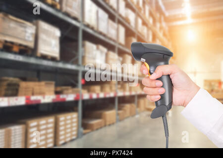 Worker checking and scanning package by laser barcode scanner in modern warehouse. Stock Photo