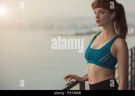 a woman runner is enjoying a morning sunrise in her sports outfit Stock Photo