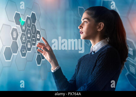 modern business woman using innovative technologies to manage her administrative work, analyzing a digital projected graph Stock Photo
