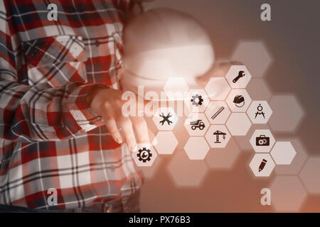 engineer is using future innovative technology, touching a holographic digital display panel with engineering options in order to manage her work Stock Photo