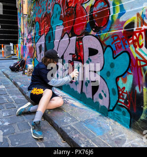 Street artist working in Hosier Lane; one of Melbourne's most iconic Street Art lane ways and a main tourist attraction. Stock Photo