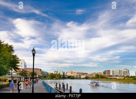 The Riverwalk with skyline in summer and Christiana River with River Taxi Boat ,  Wilmington, Delaware, USA Stock Photo