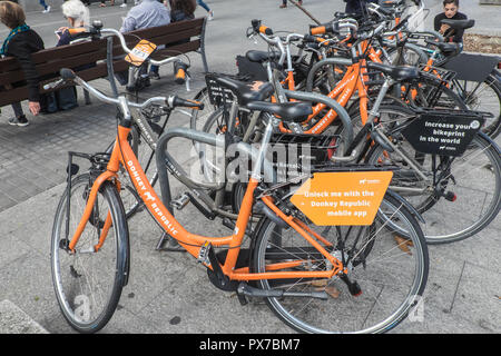 Orange,Donkey Republic,bicycles,to,rent,hire,via,dockless,app,system,at,centre,of,Barcelona,Catalan,Catalonia,Catalunya,Spain,Spanish,Europe,European, Stock Photo
