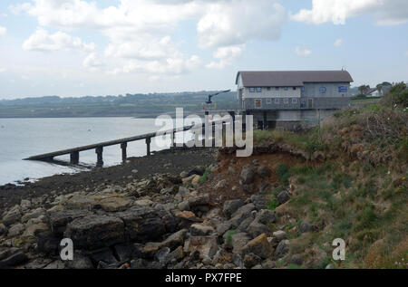 The Lifeboat Station at Moelfre with the Tamar Class RNLI Lifeboat (Kiwi) inside on the Isle of Anglesey Coastal Path, Wales, UK. Stock Photo